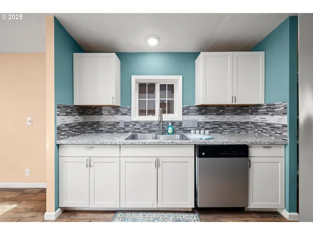 a kitchen with granite countertop a sink and cabinets