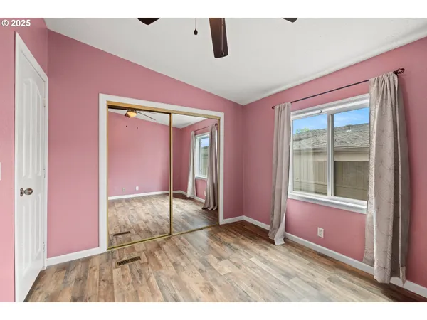 view of an empty room with wooden floor and a window