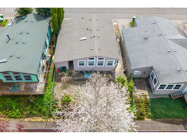 an aerial view of a house with a yard and large trees