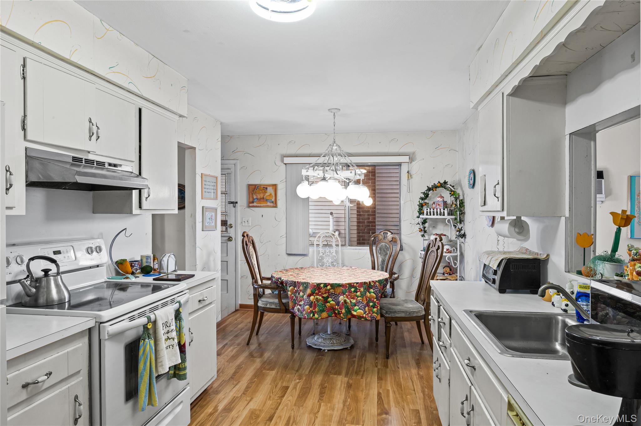 2929 Mandalay Beach Road Wantagh, NY 11793 - Photo 8 of 26 a view of a dining room with furniture a kitchen and chandelier