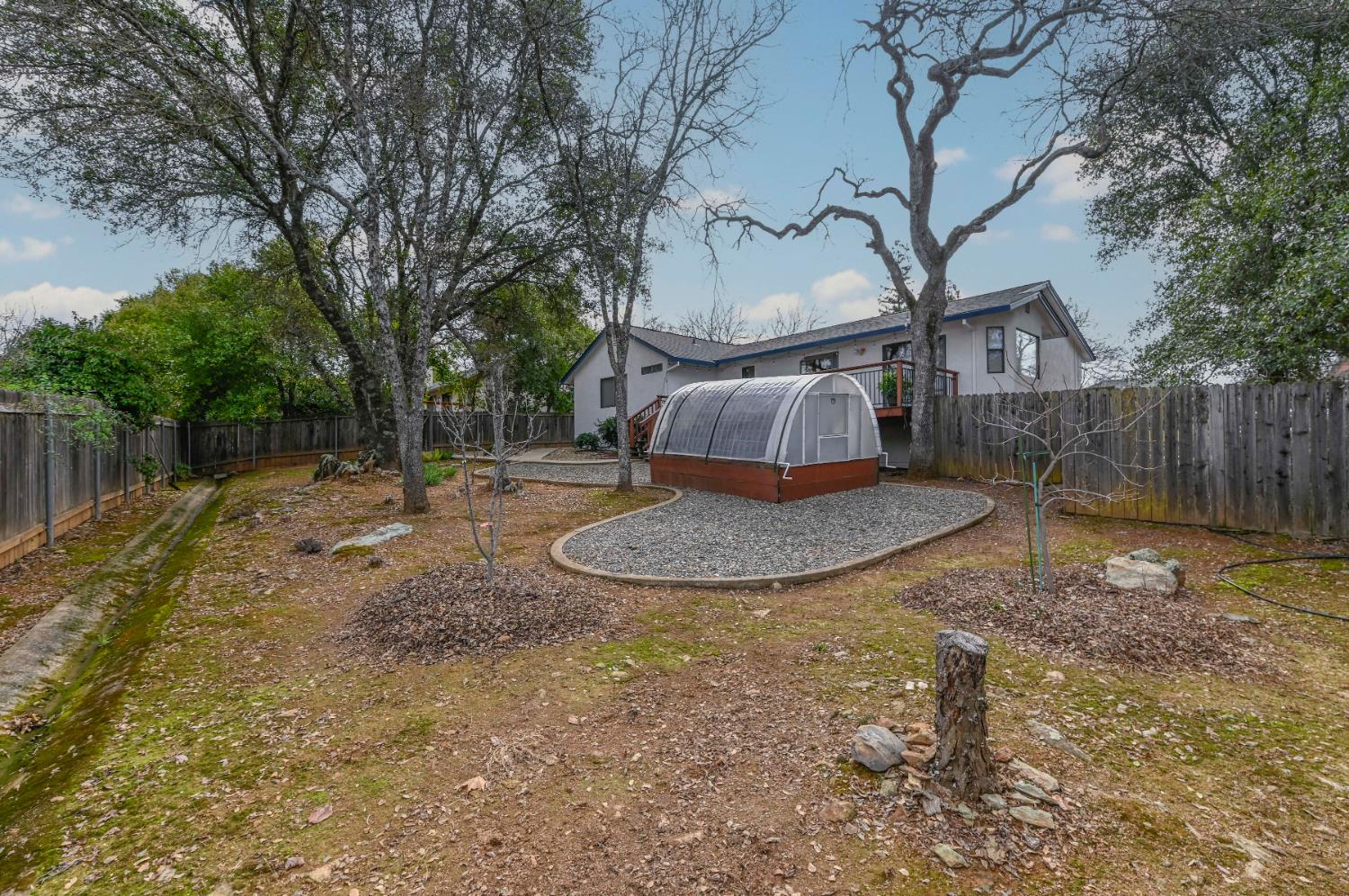 147 Rocky Ridge Lane Angels Camp, CA 95222 - Photo 21 of 61 a view of a backyard with large trees and wooden fence