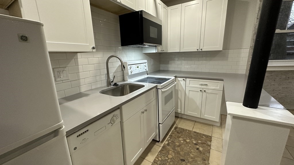 147 Winthrop Road, Unit 2 Brookline, MA 02445 - Photo 7 of 19 a kitchen with stainless steel appliances a sink dishwasher a stove and a microwave oven with cabinets