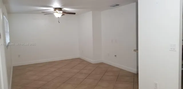 an empty room with a fan & a ceiling fan