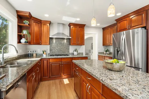 a kitchen with stainless steel appliances granite countertop a sink stove and refrigerator