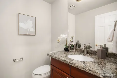 a bathroom with a granite countertop sink and a mirror