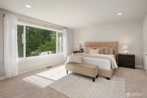 a bedroom with a bed and a large window