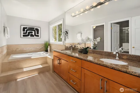 a spacious bathroom with a granite countertop tub sink and mirror