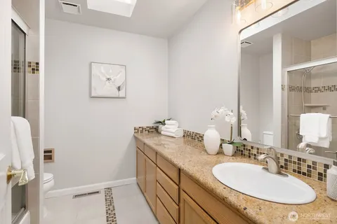 a bathroom with a granite countertop sink and a mirror