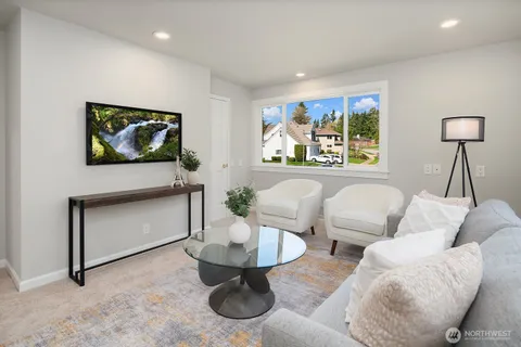 a living room with furniture a window and a flat screen tv