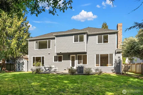 a front view of a house with a yard porch and a tree
