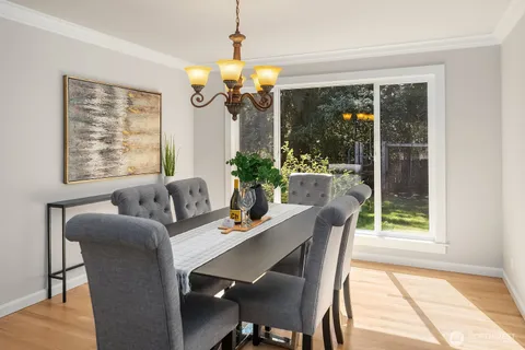 a dining room with furniture a chandelier and wooden floor