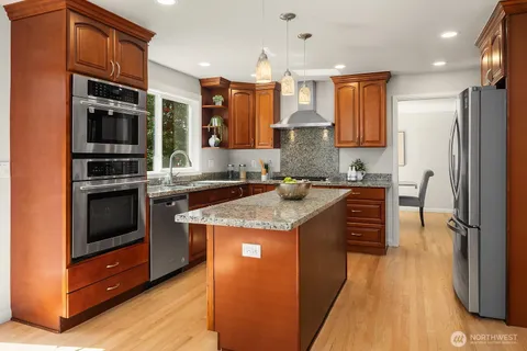 a kitchen with stainless steel appliances granite countertop a stove a sink and a refrigerator