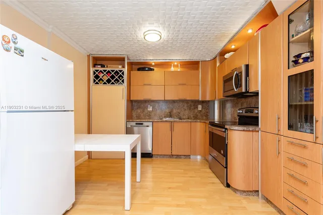 a kitchen with stainless steel appliances granite countertop a refrigerator and a stove top oven