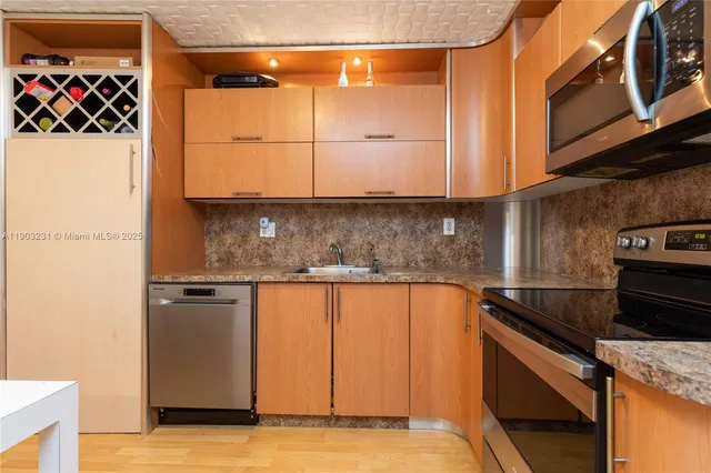 a kitchen with stainless steel appliances granite countertop a sink and a stove