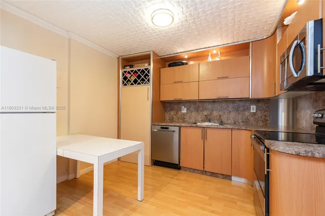a kitchen with stainless steel appliances granite countertop a sink and a refrigerator