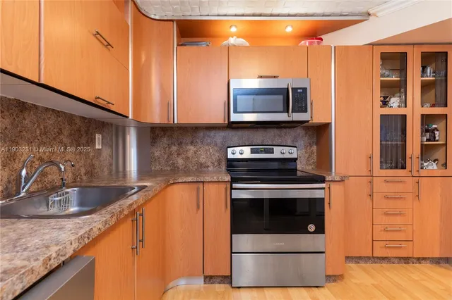 a kitchen with stainless steel appliances granite countertop a sink and a stove