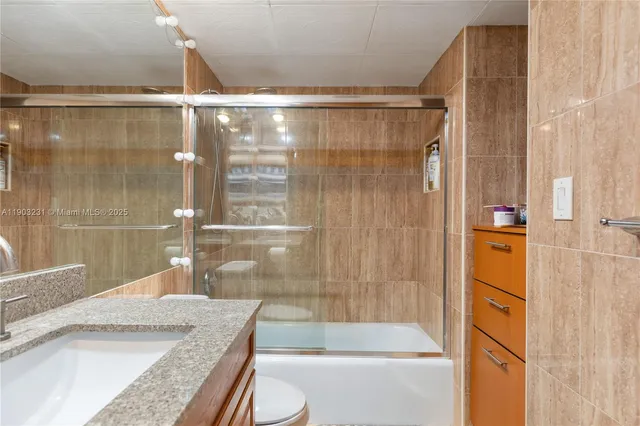a bathroom with a granite countertop shower and a sink