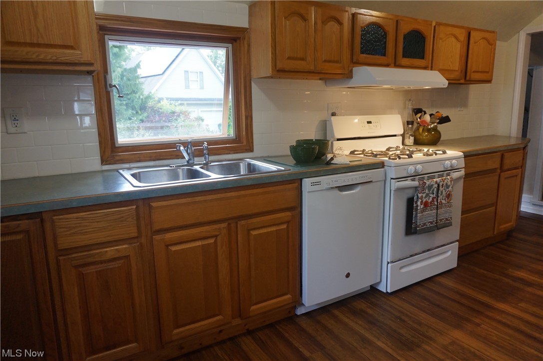 7311 Lake Road East Madison, OH 44057 - Photo 8 of 35 Kitchen featuring clean white appliances, honey oak cabinets, white subway tile backsplash, and laminate flooring.