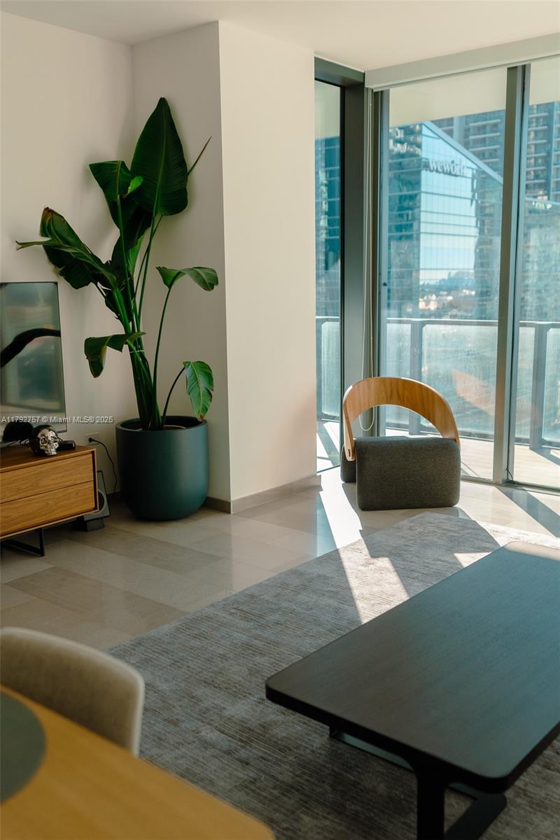 68 Southeast 6th Street, Unit 1204 Miami, FL 33131 - Photo 21 of 48 a living room with furniture and a potted plant