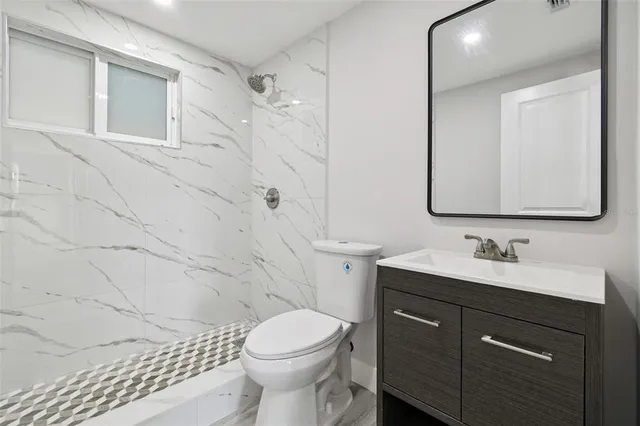 a bathroom with a toilet sink and mirror