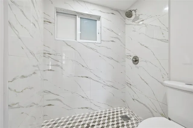 a bathroom with a toilet and a shower