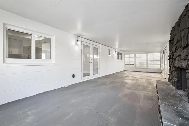 a view of an empty room with a fireplace and a window