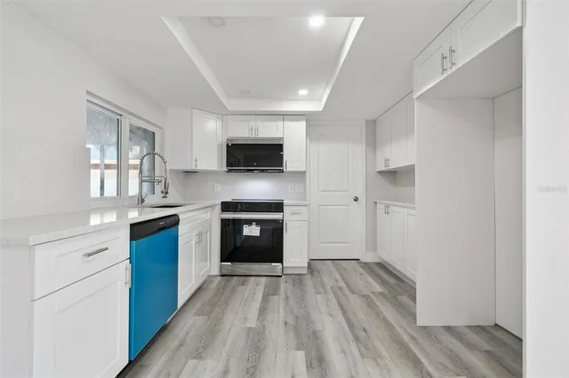 a kitchen with sink a microwave and cabinets