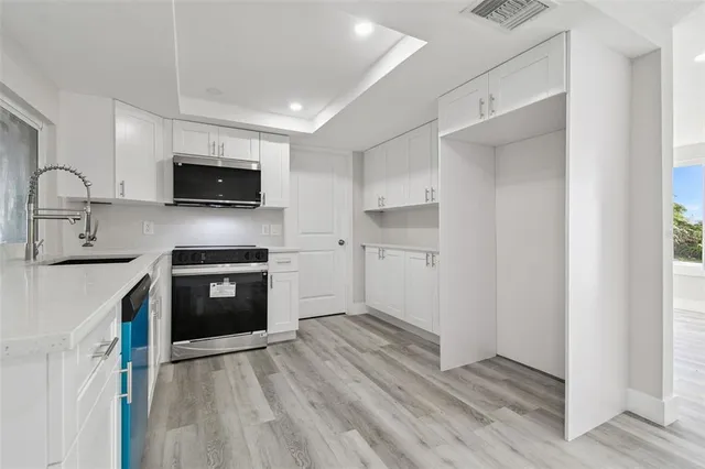 a kitchen with kitchen island a sink stainless steel appliances and cabinets