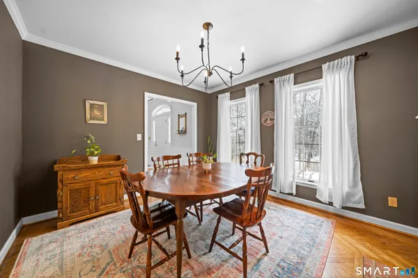 a kitchen with stainless steel appliances a stove a sink a dining table and chairs with wooden floor