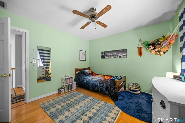 a bedroom with a bed and wooden floor