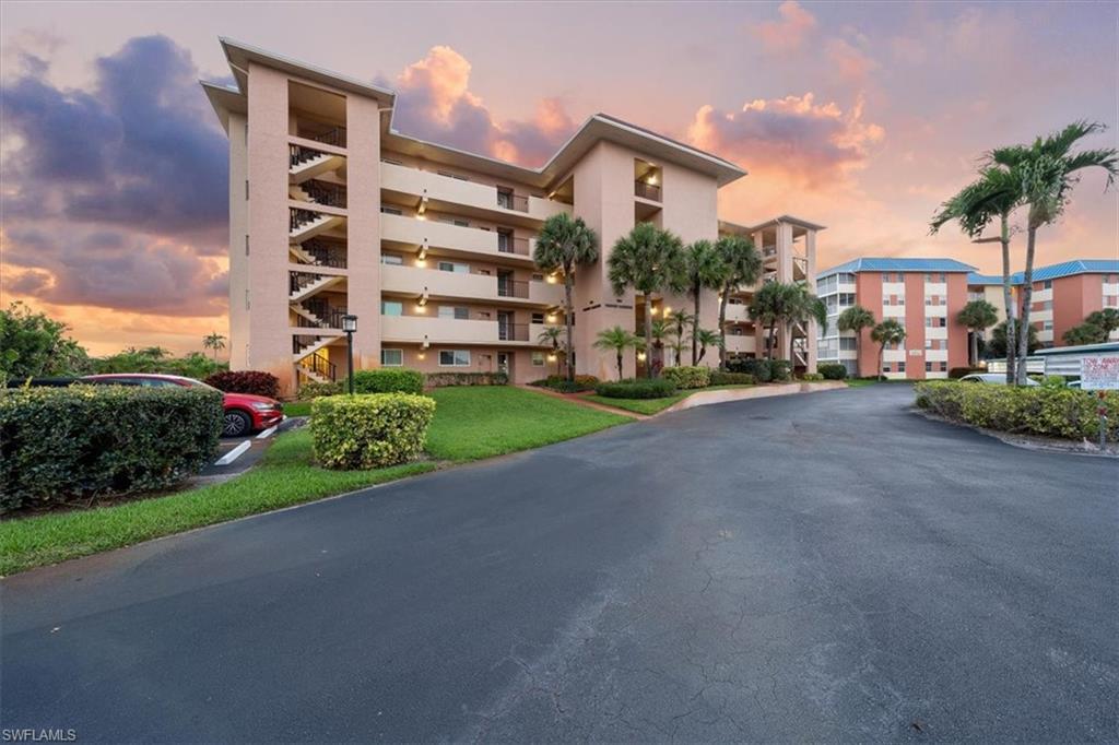 190 Pebble Beach Boulevard, Unit 502 Naples, FL 34113 - Photo 1 of 27 a view of a street with a building and trees in the background