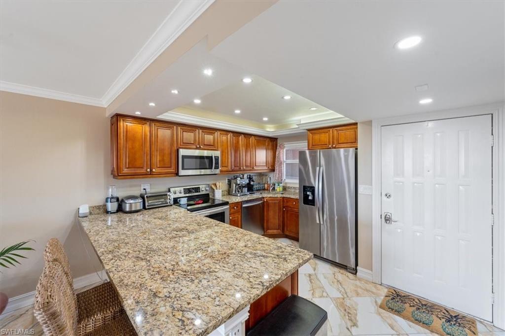 190 Pebble Beach Boulevard, Unit 502 Naples, FL 34113 - Photo 11 of 27 a kitchen with stainless steel appliances granite countertop a sink refrigerator and cabinets