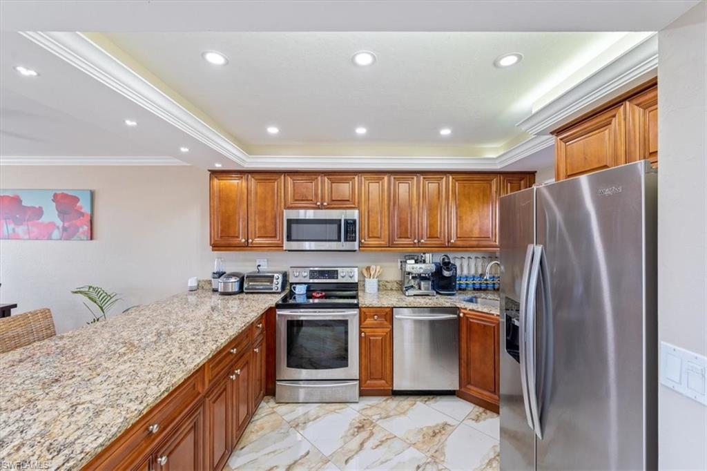 190 Pebble Beach Boulevard, Unit 502 Naples, FL 34113 - Photo 12 of 27 a kitchen with stainless steel appliances granite countertop a refrigerator a sink a stove top oven a refrigerator and dishwasher