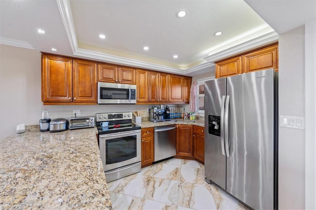 190 Pebble Beach Boulevard, Unit 502 Naples, FL 34113 - Photo 13 of 27 a kitchen with stainless steel appliances granite countertop a refrigerator a stove top oven a sink and dishwasher