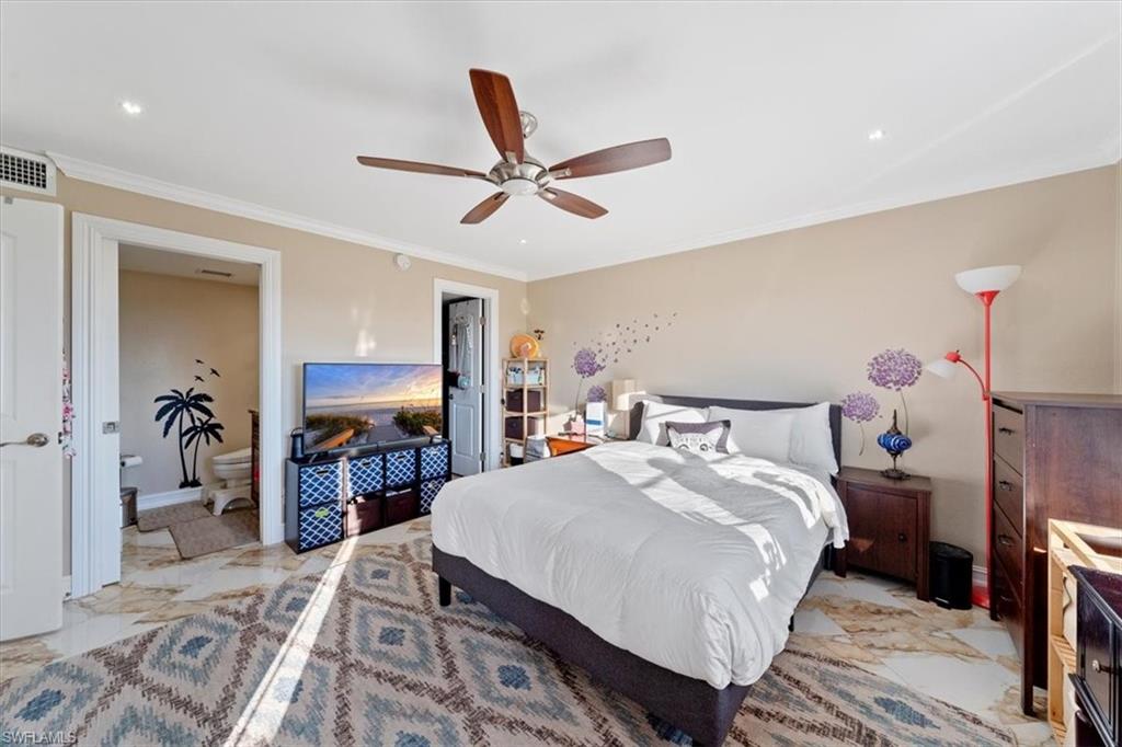 190 Pebble Beach Boulevard, Unit 502 Naples, FL 34113 - Photo 16 of 27 a bedroom with a bed and a chandelier