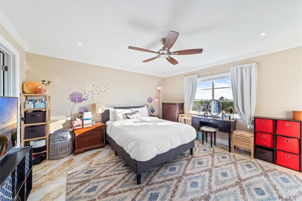 190 Pebble Beach Boulevard, Unit 502 Naples, FL 34113 - Photo 17 of 27 a bedroom with a bed and a chandelier