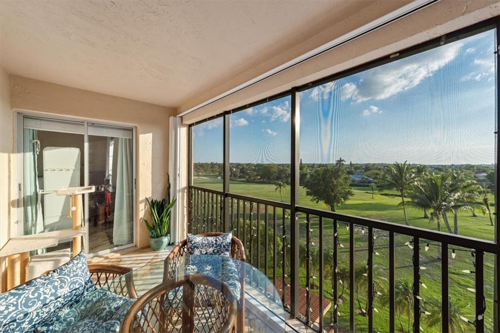 190 Pebble Beach Boulevard, Unit 502 Naples, FL 34113 - Photo 22 of 27 a view of a balcony with chairs and floor to ceiling window