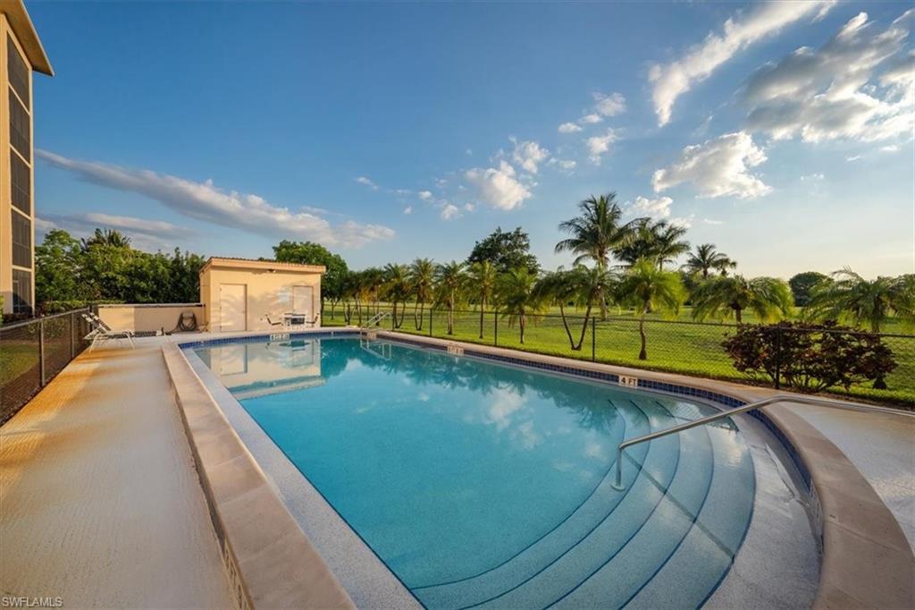 190 Pebble Beach Boulevard, Unit 502 Naples, FL 34113 - Photo 27 of 27 a view of a swimming pool with a garden and deck