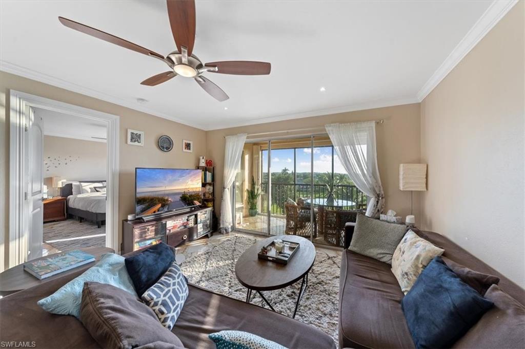 190 Pebble Beach Boulevard, Unit 502 Naples, FL 34113 - Photo 4 of 27 a living room with furniture a flat screen tv and a large window