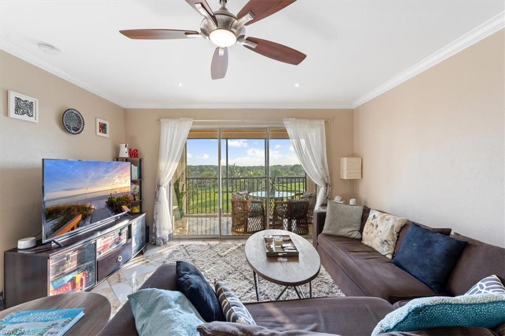 190 Pebble Beach Boulevard, Unit 502 Naples, FL 34113 - Photo 5 of 27 a living room with furniture a flat screen tv and a large window