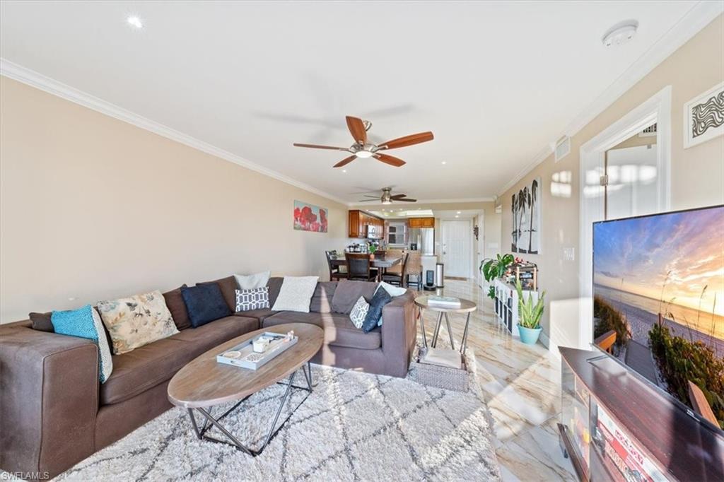 190 Pebble Beach Boulevard, Unit 502 Naples, FL 34113 - Photo 7 of 27 a living room with furniture and a flat screen tv