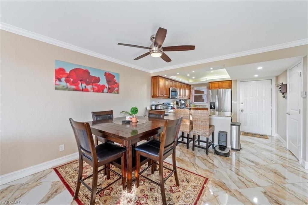 190 Pebble Beach Boulevard, Unit 502 Naples, FL 34113 - Photo 8 of 27 a view of a dining room with furniture and wooden floor