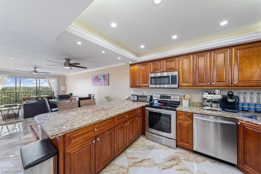 190 Pebble Beach Boulevard, Unit 502 Naples, FL 34113 - Photo 10 of 27 a kitchen with stainless steel appliances granite countertop counter space a sink and cabinets