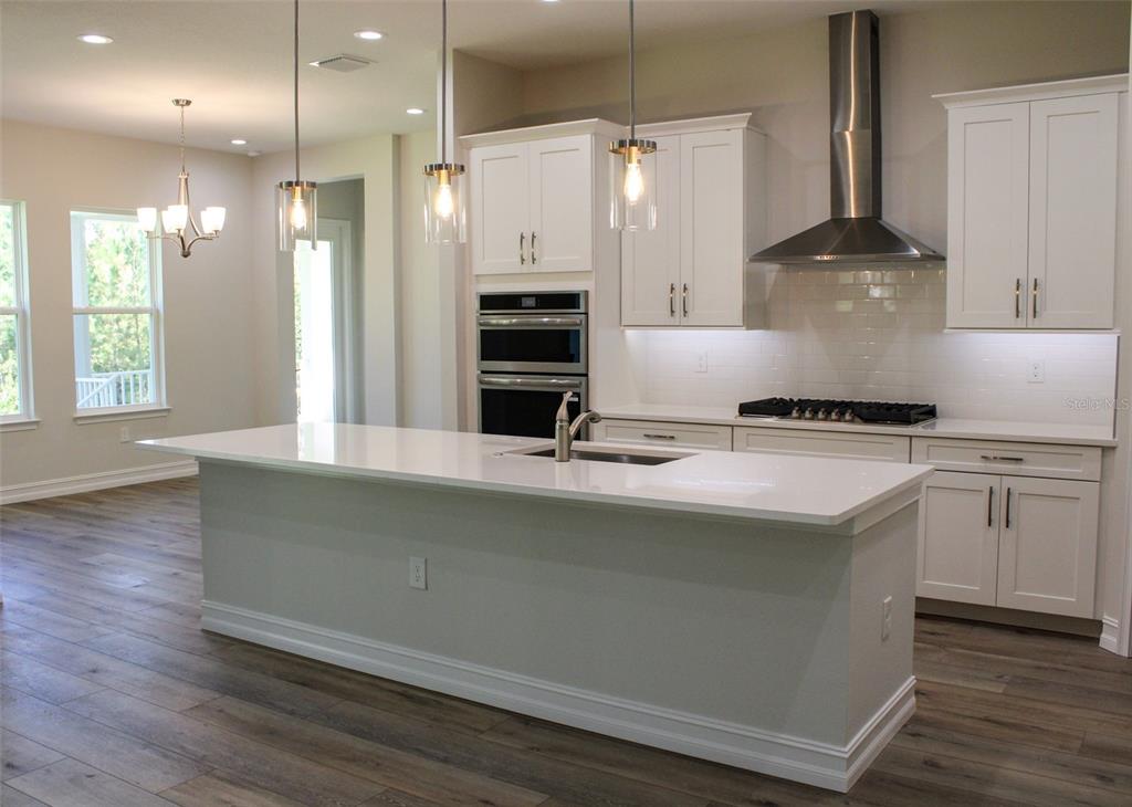 6671 Summit View Drive Brooksville, FL 34601 - Photo 11 of 37 a kitchen with stainless steel appliances granite countertop a sink a stove and a refrigerator