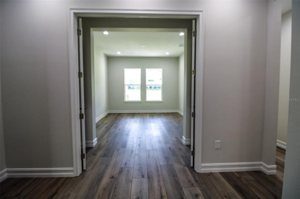 6671 Summit View Drive Brooksville, FL 34601 - Photo 21 of 37 an empty room with wooden floor and windows