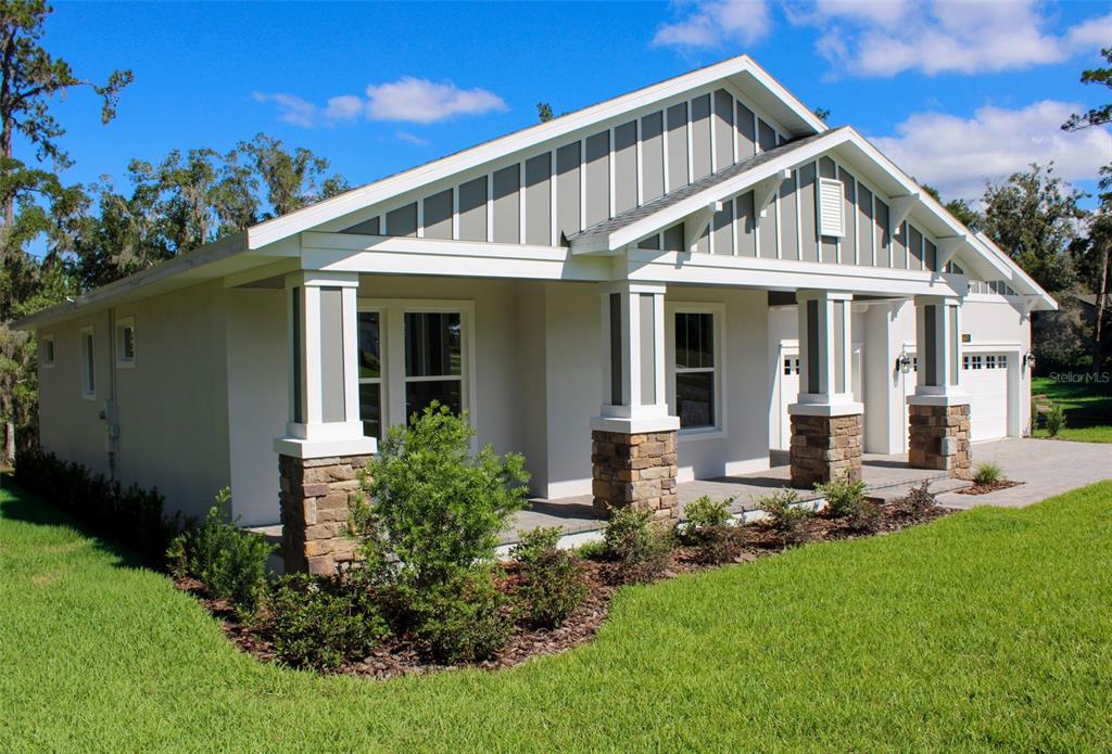 6671 Summit View Drive Brooksville, FL 34601 - Photo 4 of 37 a front view of a house with a yard table and chairs