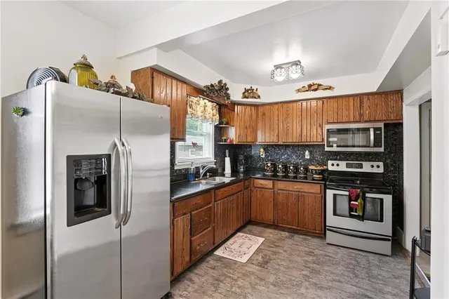 a kitchen with stainless steel appliances granite countertop a refrigerator and a stove top oven