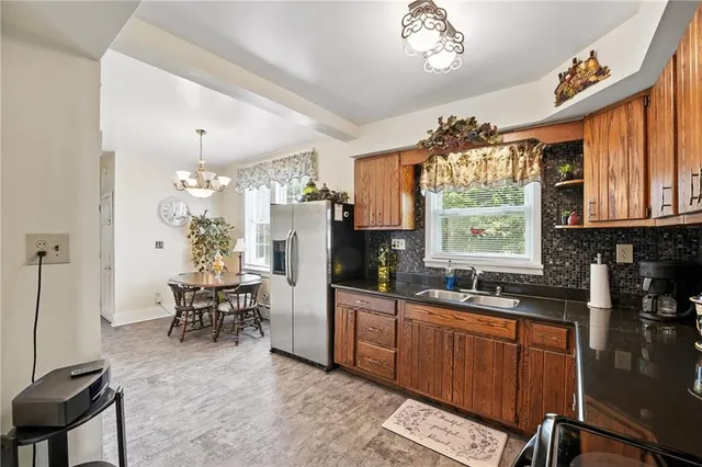 a kitchen with granite countertop a sink appliances dining table and chairs