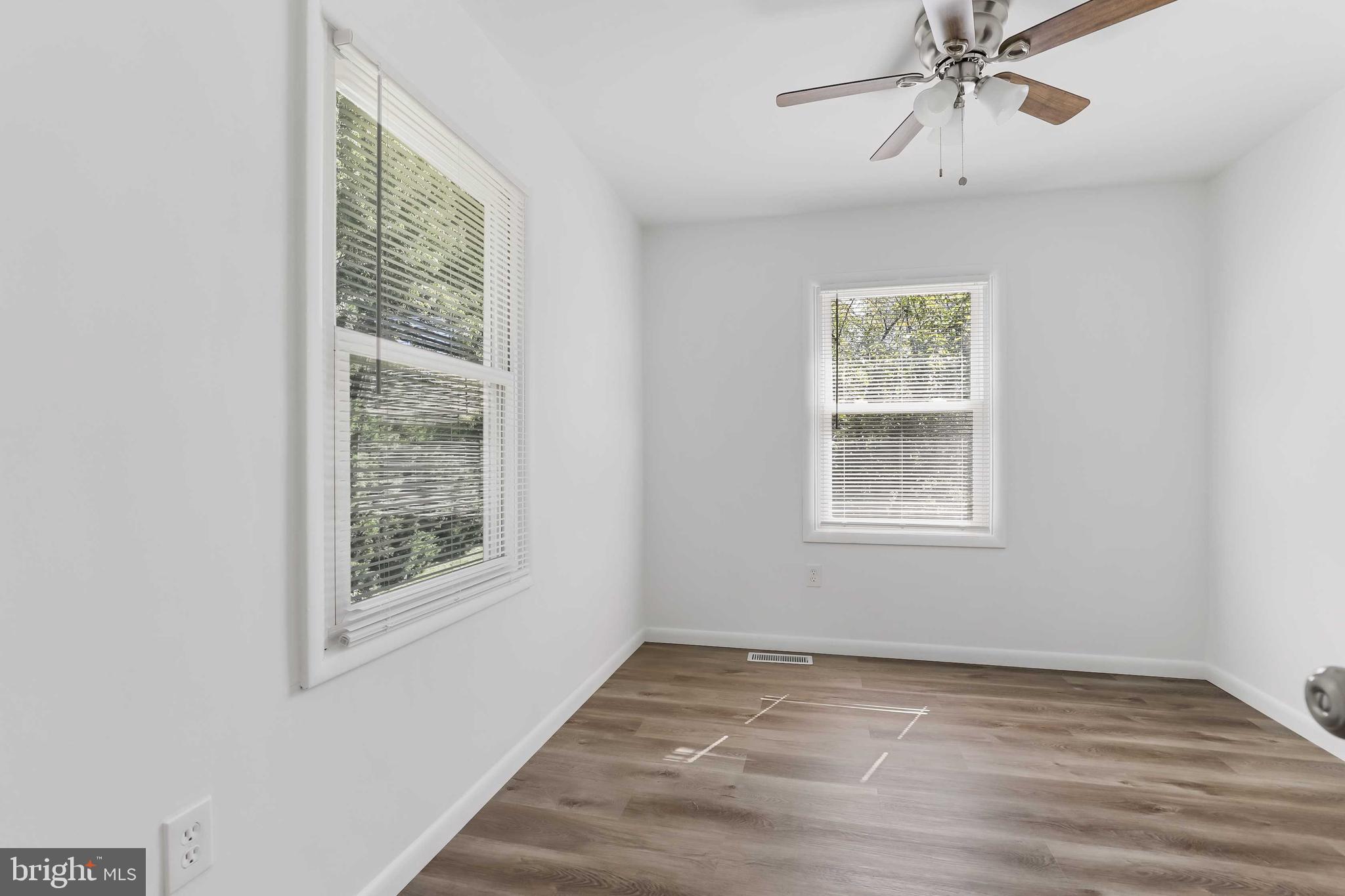 1634 Mt Airy Court Crofton, MD 21114 - Photo 19 of 40 a view of an empty room with wooden floor and a window