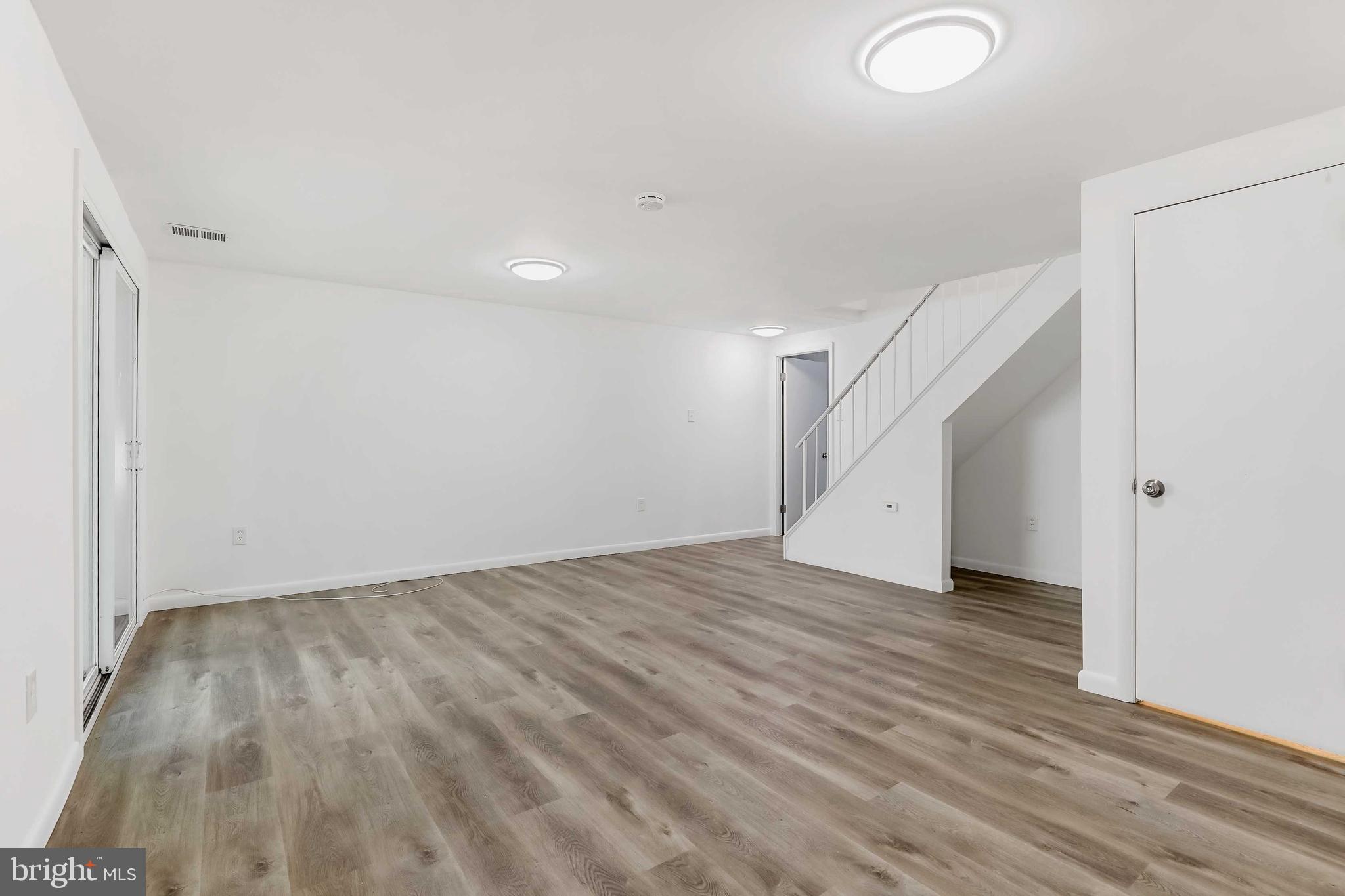 1634 Mt Airy Court Crofton, MD 21114 - Photo 27 of 40 a view of an empty room with wooden floor and stairs